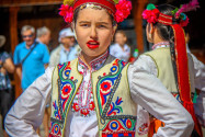 Bunt gekleidete Tänzerinnen und Tänzer ziehen beim Rosenfestival durch die Straßen von Kazanlak, Bulgarien - © LuminatePhotos by judith/Shutterstock