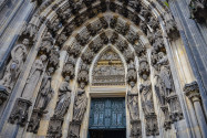 Das Eingangsportal des mächtigen Kölner Doms ist mit reichem Figurenschmuck umgeben, Deutschland - © Gunn Benchaporn / Shutterstock