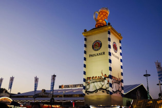 Blick auf das nächtlich beleuchtete Paulaner Bierzelt mit dem Turm davor, Münchner Oktoberfest, Deutschland