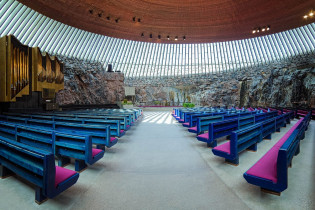 Die Innenwände der Tempelliaukio-Kirche bestehen aus nacktem Stein, das Dach aus poliertem Kupfer und für die Beleuchtung sorgen 180 langgestreckte Fenster, Helsinki, Finnland