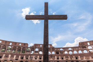 Das Bronzekreuz im Kolosseum von Rom, Italien, erinnert an das Christenblut, welches im Sand der Arena versickerte