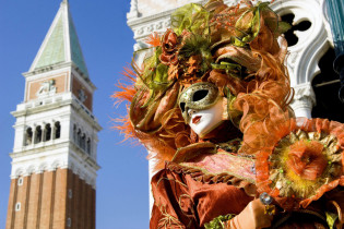 Spektakuläre Maske vor dem Campanile am Markusplatz beim Karneval von Venedig, Italien