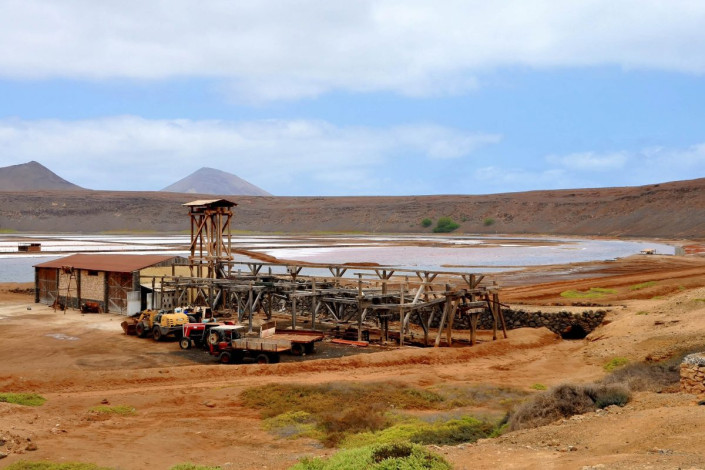 Hölzerne Baracken und verlassene Maschinen auf den Salzfeldern von Pedra de Lume formen eine einzigartige bizarre Szenerie unter der gleißenden Sonne über Sal, Kap Verde