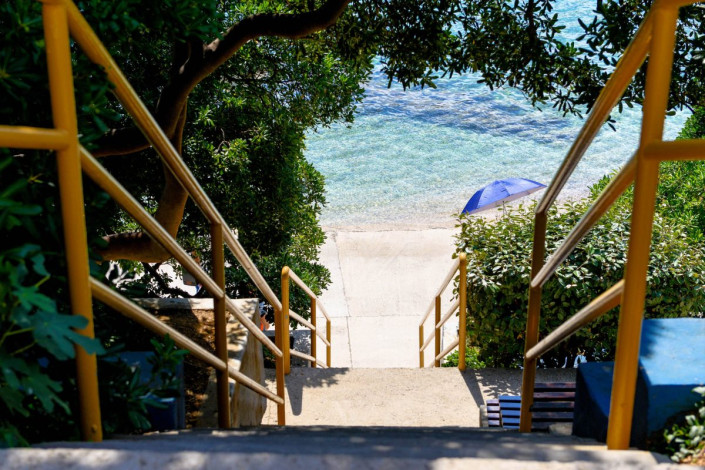 Von der Hauptstraße durch Baska führen mehrere befestigte Treppen direkt zum weitläufigen Strand von Baska, Krk, Kroatien