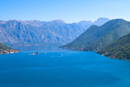 Panoramablick auf die Kotorbucht in Montenegro, links im BIld die Stadt Perast, in der MItte des Sees die Insel Gospa od Škrpjela