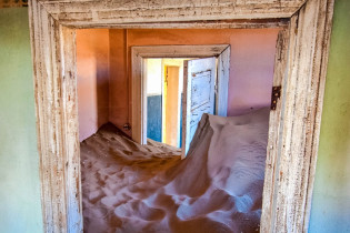 Die Häuser in Kolmanskop, in denen früher reiche deutsche Herrschaften wohnten, werden zunehmend vom afrikanischen Sand begraben, Namibia