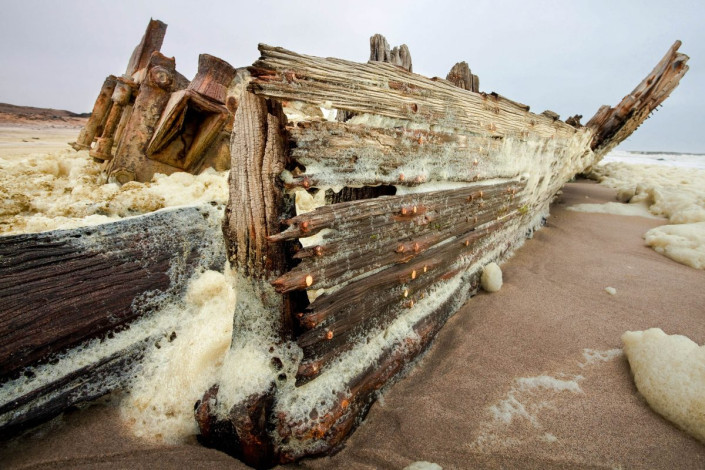 Langsam aber sicher verrotten die hölzerenen Rümpfe der Schiffswracks an der Skelettküste in Namibia