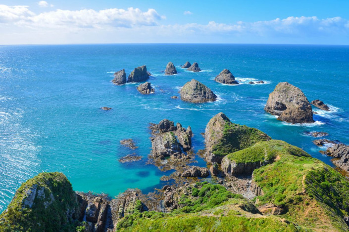 Der Nugget Point auf der Südinsel von Neuseeland hat seinen Namen von den Nuggets, jenen Felsen, die vor dem Kap aus dem Meer ragen