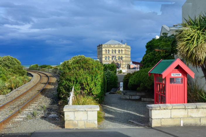 Historische Waggons kutschieren Besucher entlang der Hafenpromenade bis zur malerischen Friendly Bay von Oamaru, Neuseeland