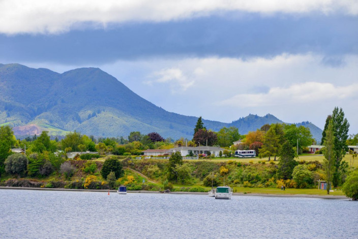 Vor der Kulisse eindrucksvoller Vulkangipfel lässt es sich am Lake Taupo in Neuseeland einen entspannten Tag am See genießen