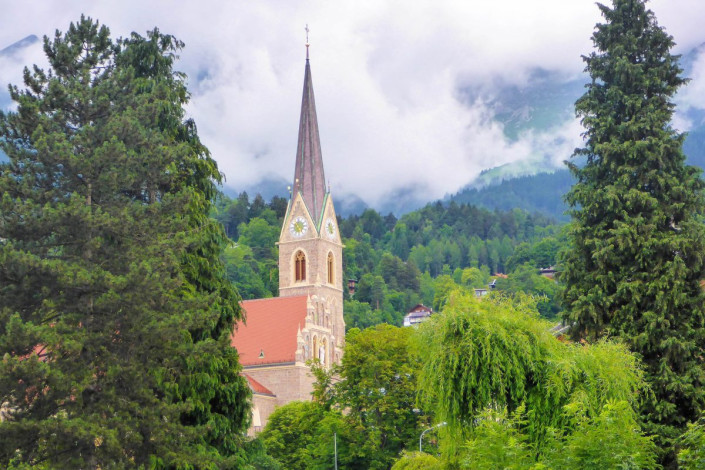 Die Pfarrkirche St. Nikolaus ragt am gegenüberliegenden Innufer der Altstadt von Innsbruck in den Himmel, Österreich