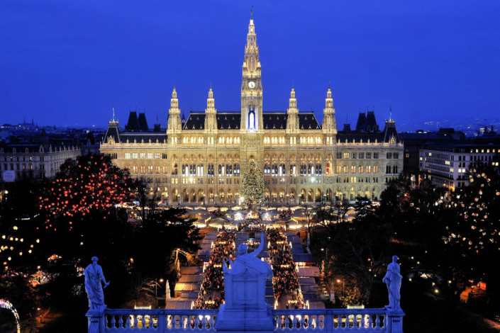Blick vom Burgtheater über den Christkindlmarkt auf das weihnachtlich beleuchtete Wiener Rathaus, Österreich