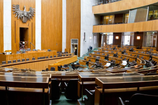 Der Sitzungssaal des Nationalrates im Parlament ist ein typisches Beispiel der Architektur der 1950er Jahre und ist weitgehend schmucklos, Wien, Österreich