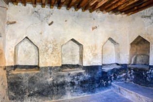 Erstaunglich gut erhaltenerer Raum mit Nischen und Holzdecke in einer Lehmhütte im Wadi bani Habib, Oman