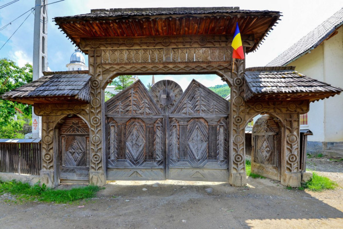 Zur Holzkirche von Botiza führt ein kunstvoll geschnitztes Holztor, Rumänien