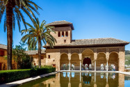 Pavillon mit einem Bogengang und Turm am Pool im Palacio del Partal in der Alhambra, Granada, Spanien - © Pete Niesen / Shutterstock