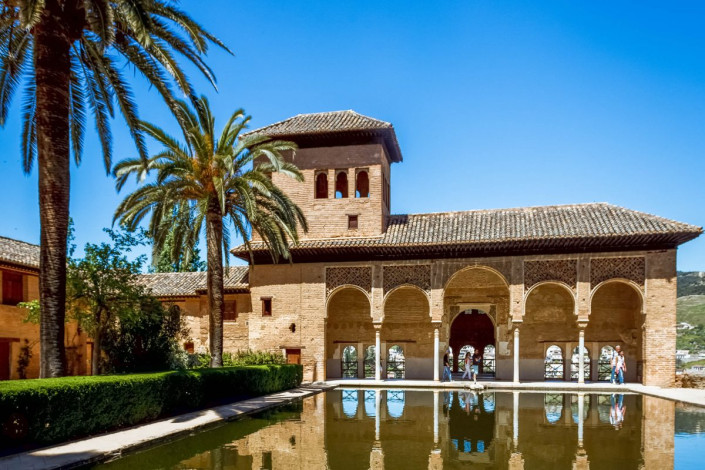 Pavillon mit einem Bogengang und Turm am Pool im Palacio del Partal in der Alhambra, Granada, Spanien
