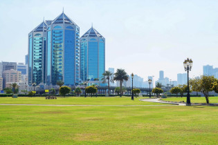 Blick vom Ittihad Park auf die spiegelnden Türme der Crystal Palace Mall in Sharjah, VAE