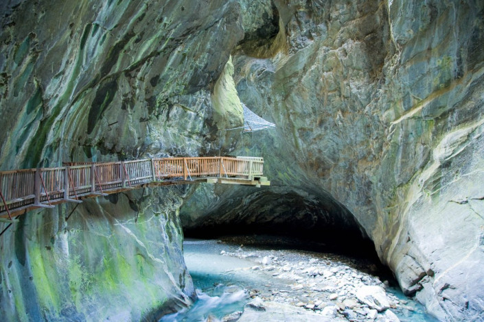 Die 200m tiefe Trientschlucht im kann auf einem Steg entlang der senkrecht aufstrebenden Bergwand besichtigt werden und führt zu einem atemberaubenden Wasserfall, Schweiz