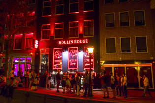 Im Rotlichtviertel „De Wallen“ in Amsterdam reiht sich ein Bordell an das nächste, die leicht bekleideten Damen räkeln hinter rot erleuchteten Schaufenstern, Niederlande