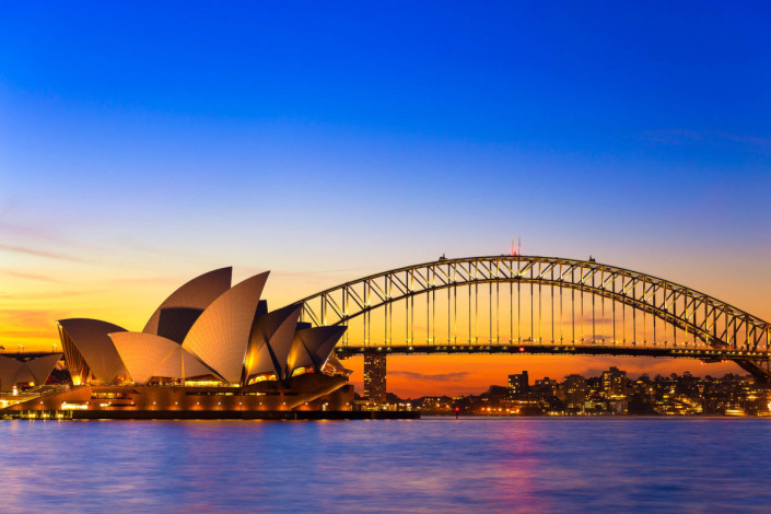 Das Opernhaus von Sydney und die berühmte Harbour Bridge kurz nach Sonnenuntergang, Australien