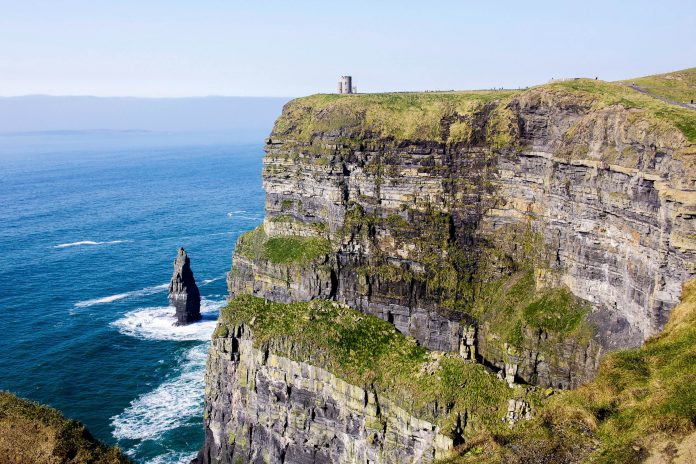 Beneath O'Brian's Tower, a prominent boulder rises out of the stormy Atlantic Ocean in front of the Cliffs of Moher, Ireland - © flog / franks-travelbox