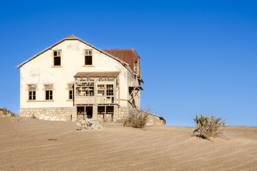 Eine Ruine in der Geisterstadt Kolmanskop im südlichen Namibia wird von der Wüste zurückerobert - © Jandrie Lombard / Shutterstock