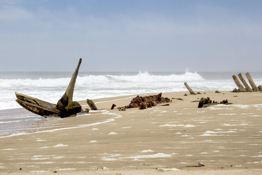 Wie verfaulte Zähne ragen die Überreste der verunglückten Schiffe aus dem Sand der Skelettküste in Namibia - © Valdecasas / Shutterstock