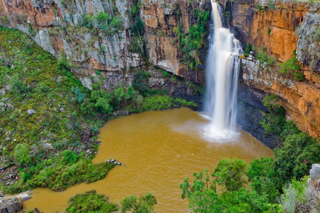 der Berlin-Wasserfall bricht sich nach einigen Metern an einem natürlich Felsen und ergießt sich in einem breiteren Strom in einen kleinen See, Sabie-Waterfall-Route, Südafrika - © natureimmortal / Fotolia
