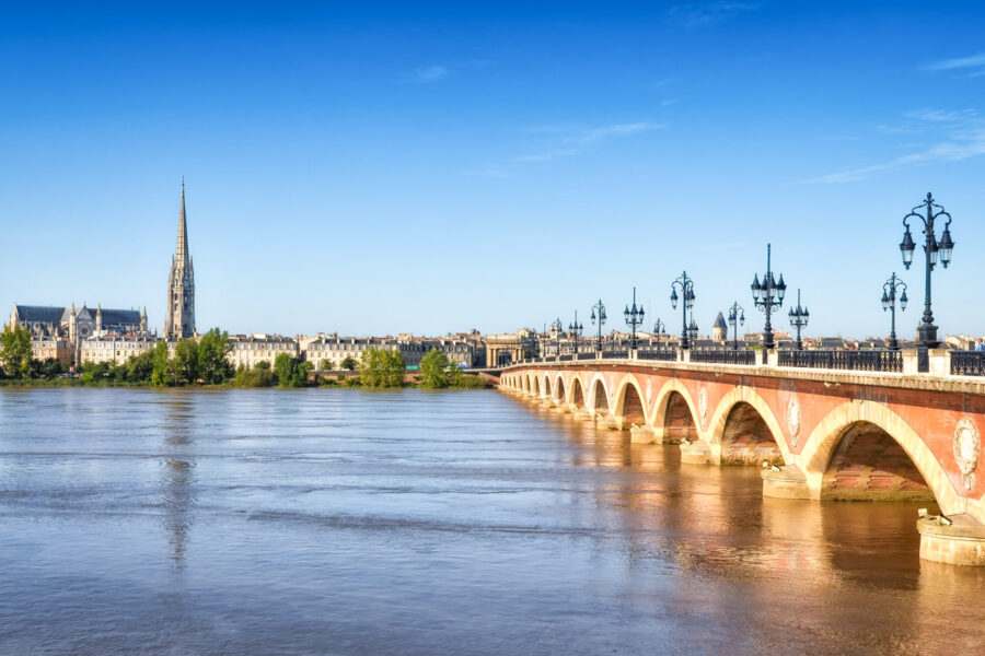 Der Pont de pierre, die erste Brücke der Stadt Bordeaux mit der Basilika Saint Michel im Hintergrund, Frankreich - © Martin M303 / Shutterstock