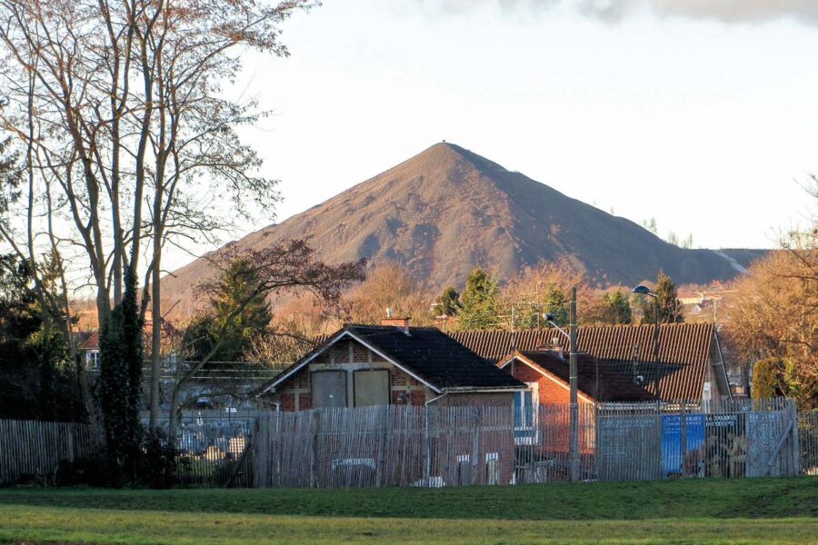 Die dunklen Kegel der Kohleberge umrahmen noch heute die Stadt Lens und erinnern an ihre große Vergangenheit als eines der Bergbau-Zentren von Frankreich - © MarnixR CC BY-SA4.0/Wiki
