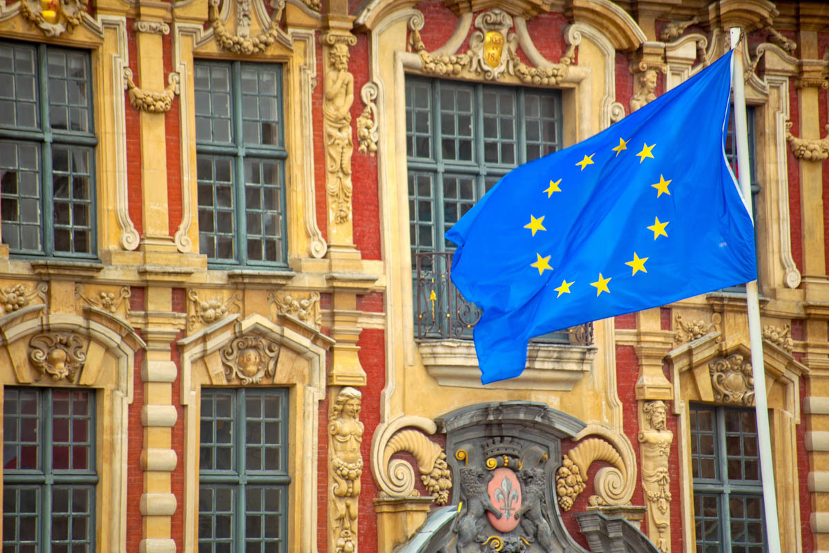 EU-Flagge vor der kunstvoll verzierten Fassade der Alten Börse am Grand Place von Lille, Frankreich