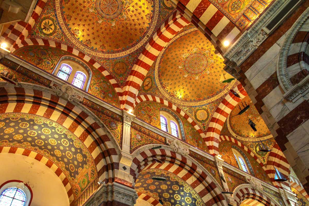 Mehrfarbig marmorierte Mauern, Wandmalereien und farbenfrohe Mosaike machen aus der Basilika Notre Dame de la Garde in Marseille, Frankreich, ein prächtiges Gesamtkunstwerk