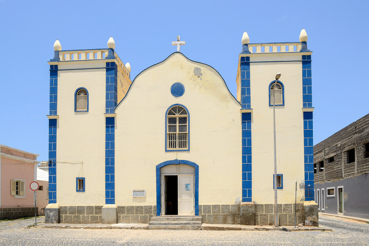 Blick auf die Kirche „Igreja da Santa Isabel“, ein schmuckes, zartgelbes Kolonialstil-Gebäude mit zwei wuchtigen Türmen in Sal Rei, Boa Vista, Kap Verde