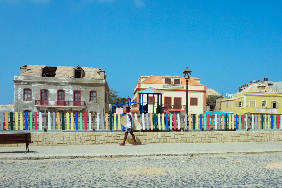 Ein Junge mit Surfbrett im Stadtzentrum von Sal Rei auf Boa Vista, Kap Verde