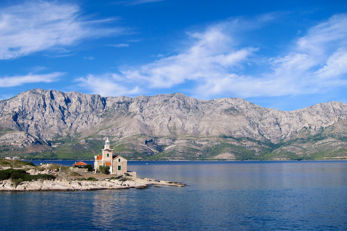 Der Leuchtturm von Sućuraj an der Ostspitze der Insel Hvar, im Hintergrund die Berge der Makarska-Riviera, Kroatien