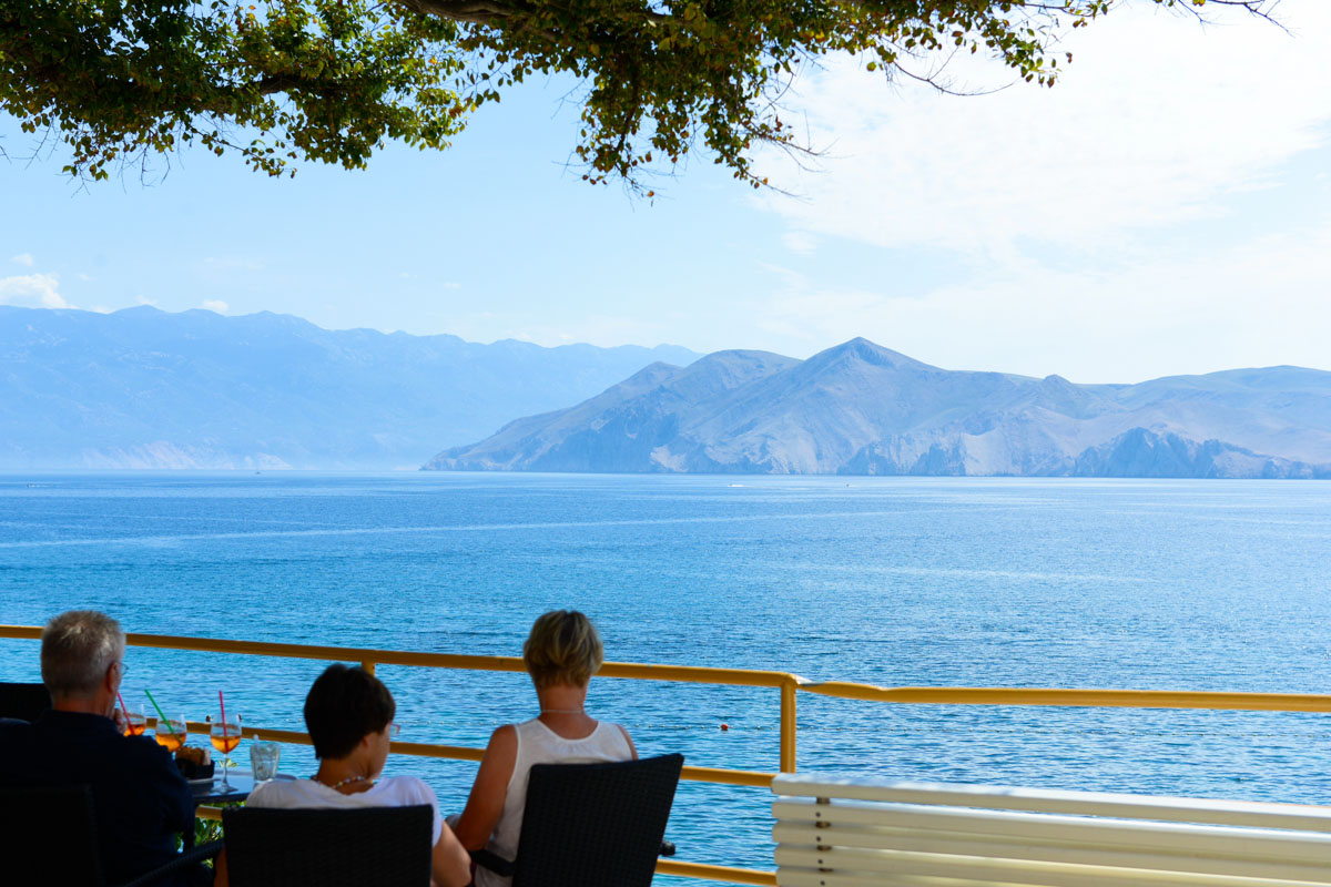 Der Strand von Baska lädt mit herrlichem Blick auf die gleichnamige Bucht zum entspannten Verweilen ein, Krk, Kroatien