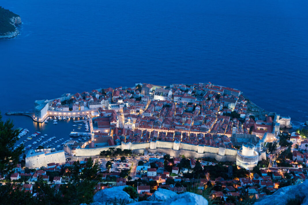 Blick vom Sergius-Berg auf das nächtlich beleuchtete Dubrovnik an der Küste von Kroatien - © anahtiris / Shutterstock