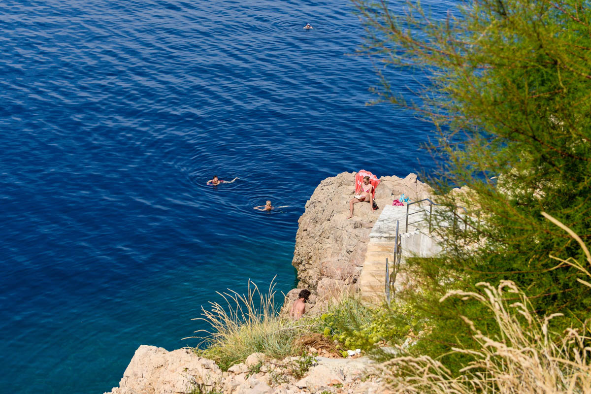 Betonierte Plätze, Kiesstrand und nackter Fels liefern in der Zgribnica-Bucht bei Vrbnik abwechslungsreiche Liege- und Einstiegsmöglichkeiten ins Mittelmeer, Kroatien