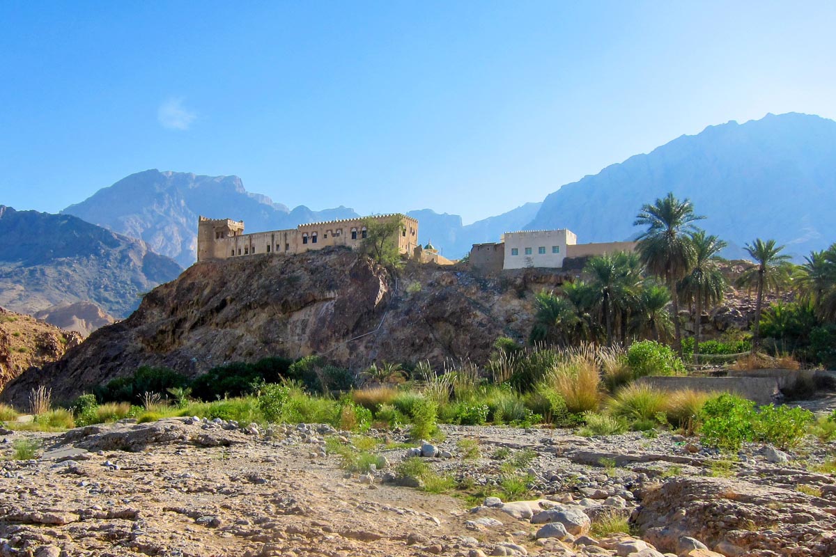 Durch idyllische Palmengärten erreicht man das malerisch gelegene Fort Al-Mazara, welches inmitten von Palmen auf einer Anhöhe über dem Wasser thront, Oman