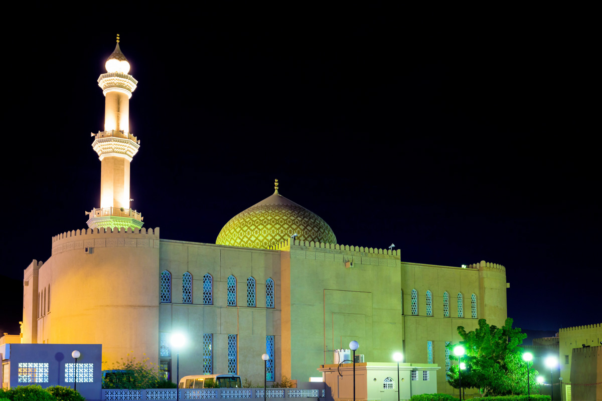 Die Sultan-Qaboos-Moschee von Nizwa überstrahlt in der Nacht das Zentrum der Altstadt, Oman