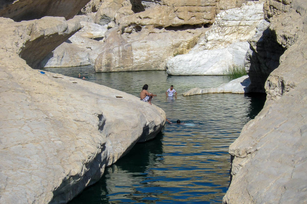 Nach der Hitze des Tages bringt das kristallklare Wasser willkommene Abkühlung für die Besucher, Wadi bani Khalid, Oman
