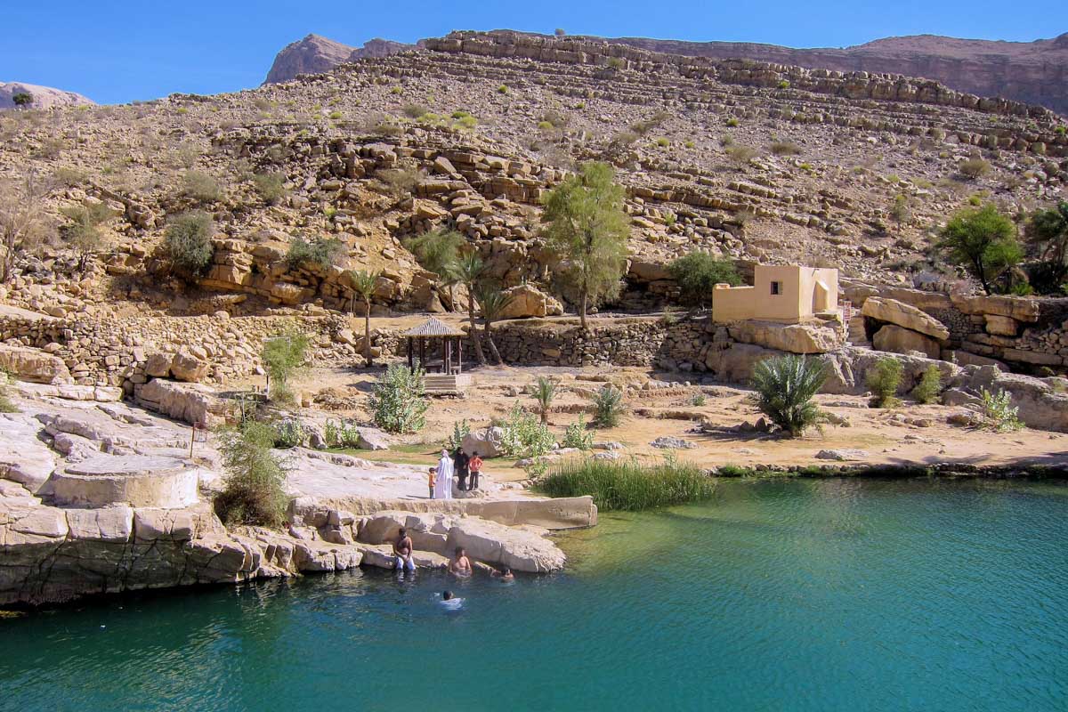Nach einem erfrischenden Planschausflug lässt man die spektakuläre Landschaft am besten im Schatten der Palmen auf sich wirken, Wadi bani Khalid, Oman