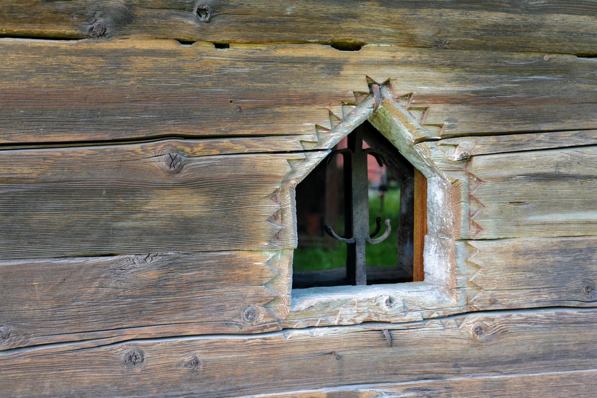 Neben dem gewaltigen Schindeldach sind auch die sorgfältigen Verzierungen der noch so kleinen Fenster an der Holzkirche von Deseşti bemerkenswert, Rumänien