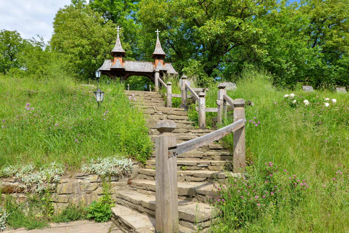 Der Aufstieg auf den Friedhofshügel zur Holzkirche von Deseşti erfolgt über eine idyllische Steintreppe, Rumänien