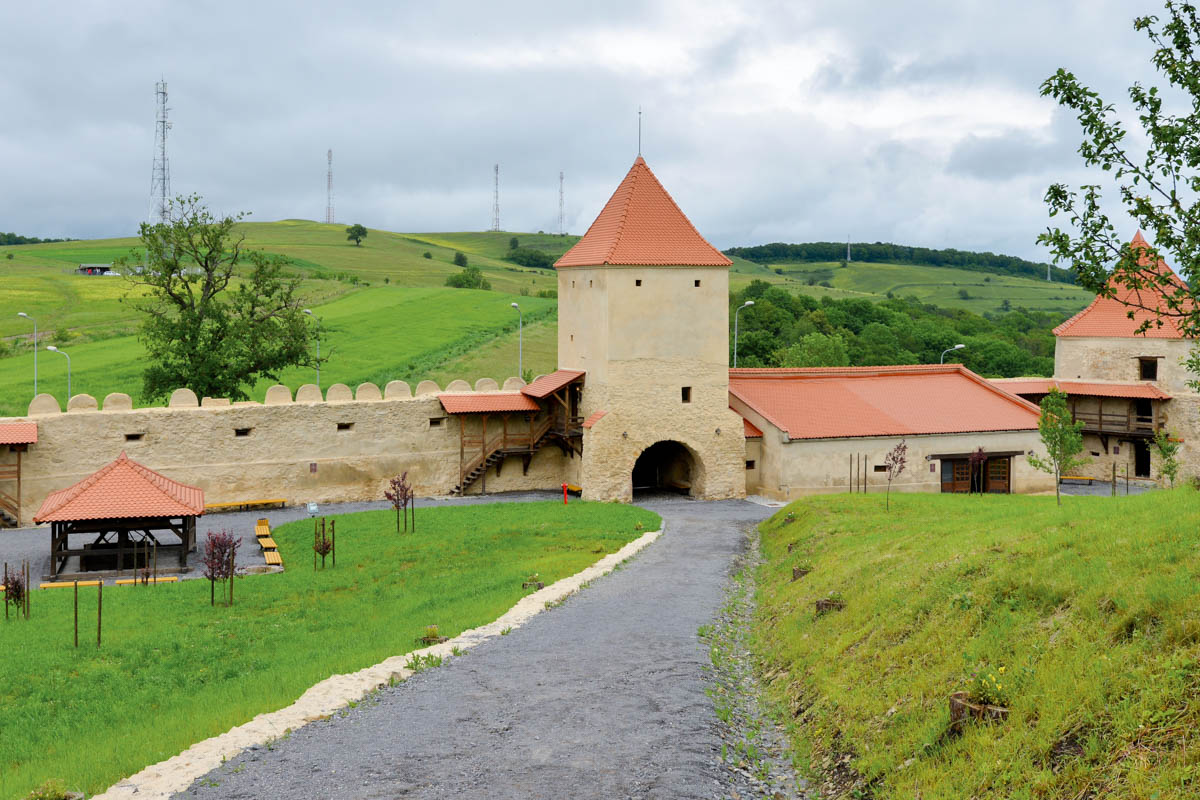 Der Zugang durch die zinnenbewährten Mauern zur unteren Burg von Rupea erfolgt unterhalb des Pulverturms, Rumänien