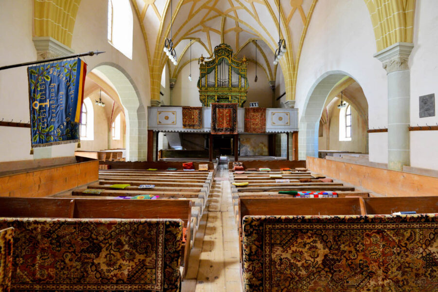 Innerhalb der Kirche fallen rustikale Bänke ohne Rückenlehne auf, die die kunstvollen Trachten der Frauen schonen sollten, Hărman, Rumänien - © FRASHO / franks-travelbox