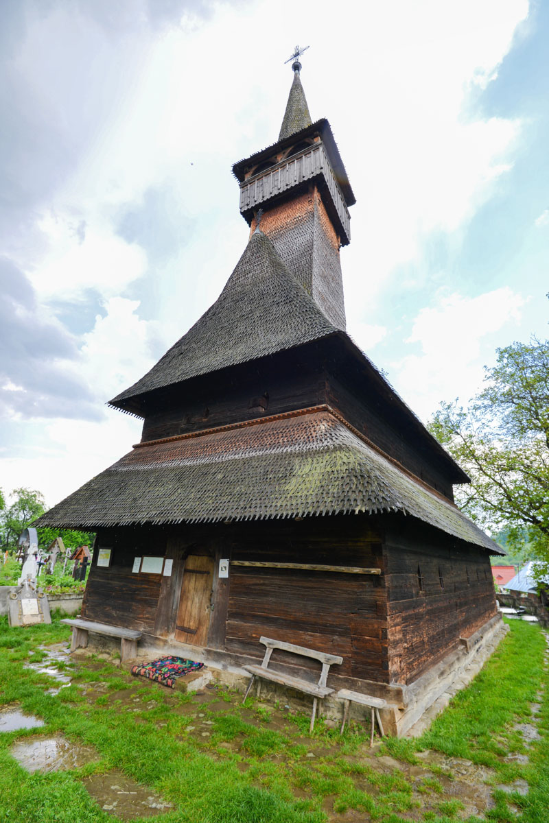 Die Kirche von Ieud in Rumänien liegt etwas außerhalb inmitten üppiger Vegetation und einem kleinen Friedhof