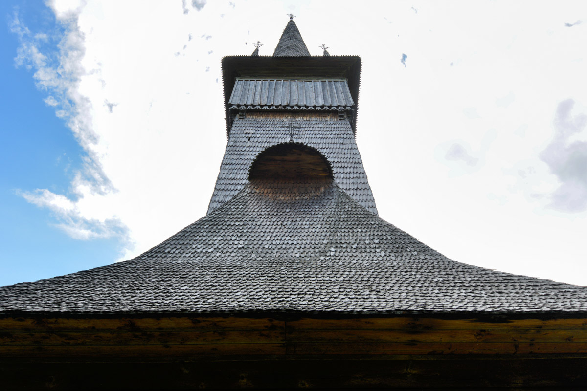 Der 47m hohe Turm fügt sich mit perfekt ausgewogenen Proportionen harmonisch in das Gesamtbild der Holzkirche von Plopis ein, Rumänien