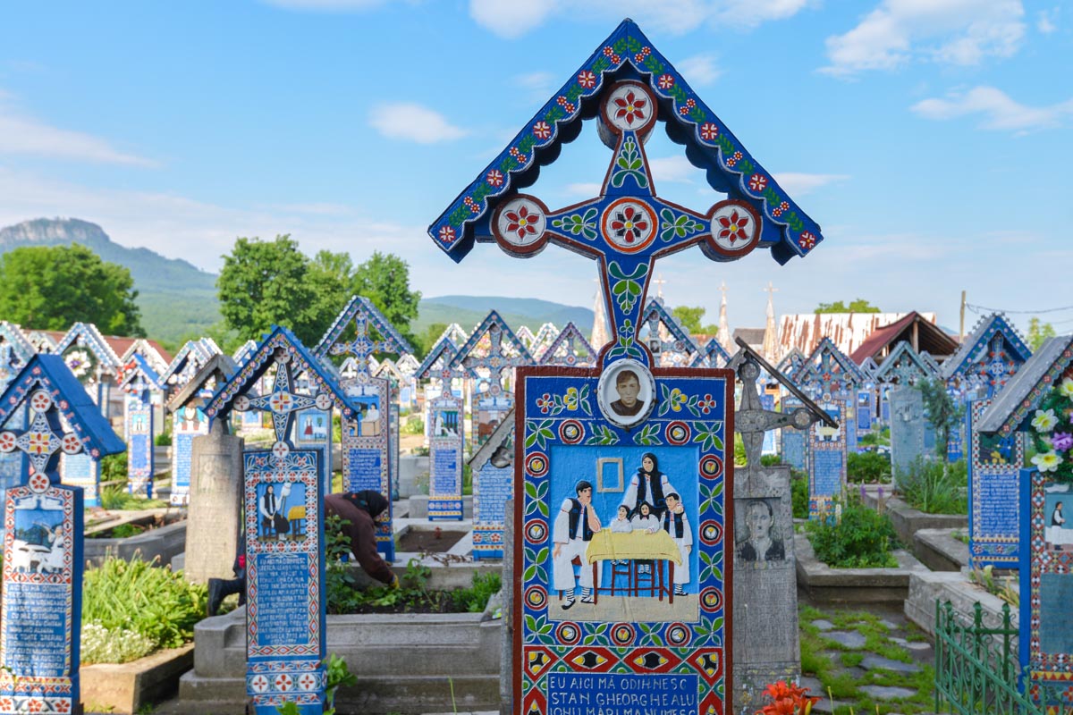 Der Fröhliche Friedhof in Săpânţa, Rumänien, ist aufgrund seiner farbenfroh bemalten Holzkreuze und den humorvoll-spöttischen Nachrufen weltweit einzigartig